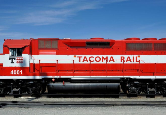 A side view of a red Tacoma Rail locomotive with the number 